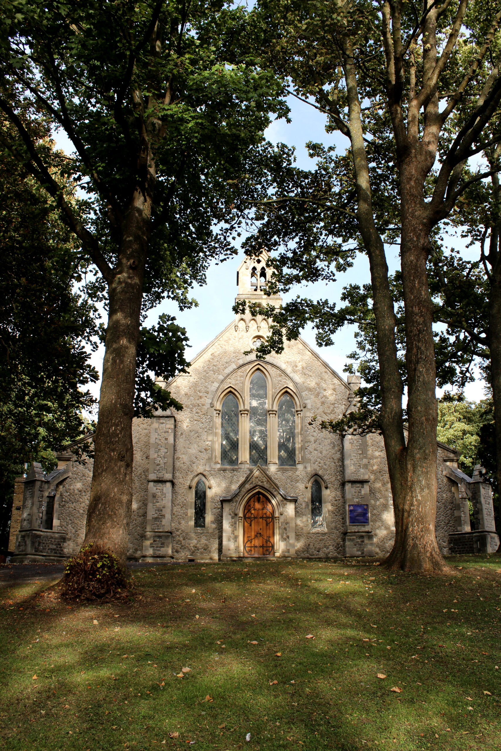 An image of St Barbara's Garrison Church, surrounded by trees on a sunny Autumn day.