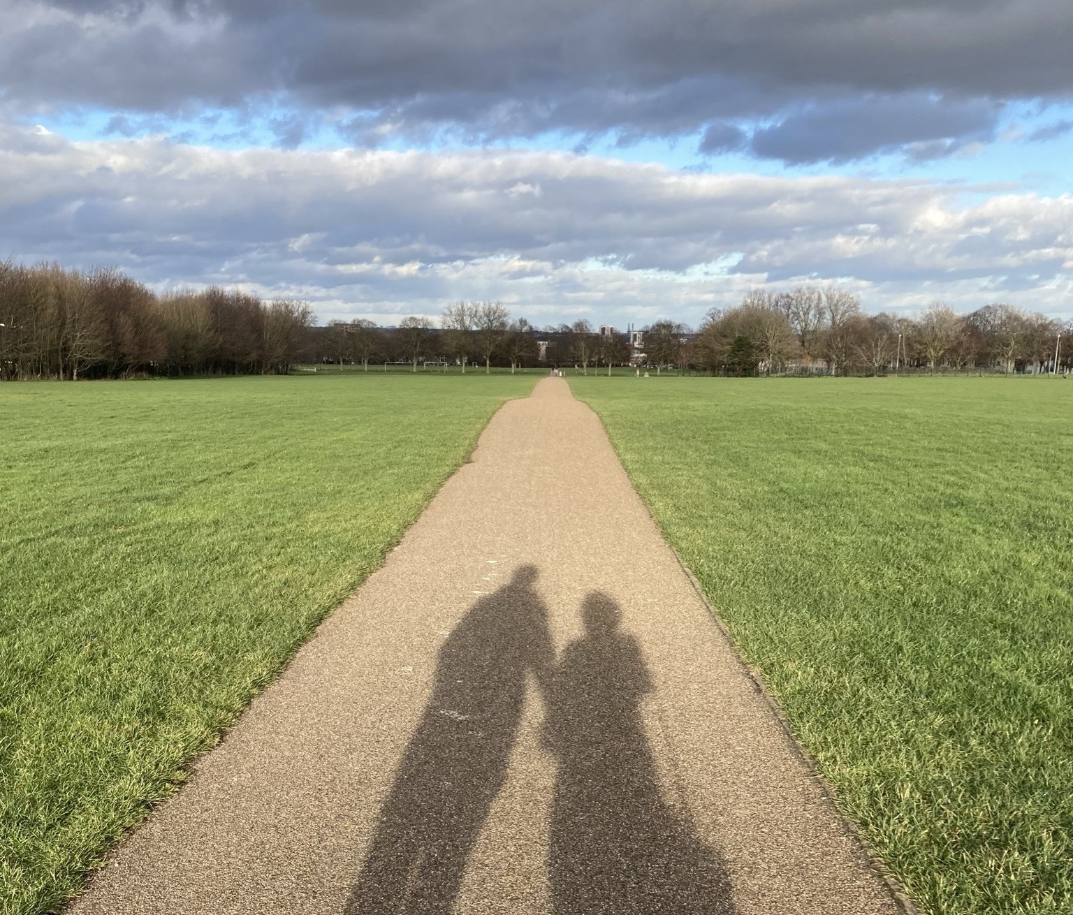 A shadow of a man and a woman holding hands on a path in the Great Lines.