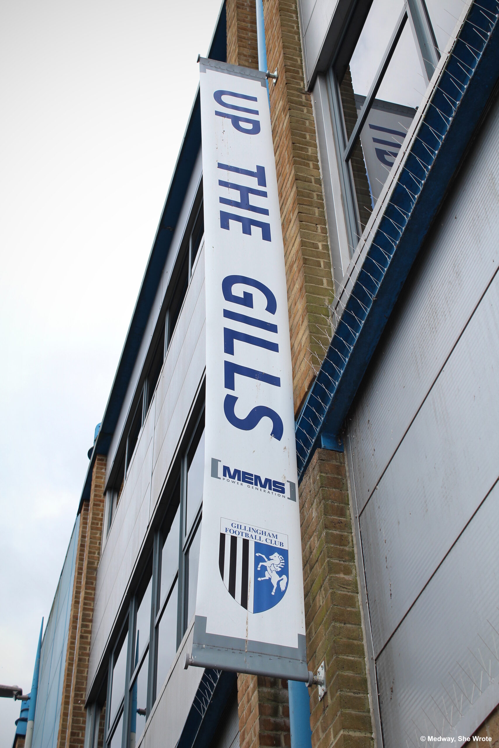 A vertical banner reading 'Up the Gills' hanging on the side of Priestfield Stadium