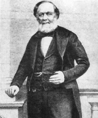 A black and white image of William  Calcraft. He has a white beard and is dressed in Victorian clothing.