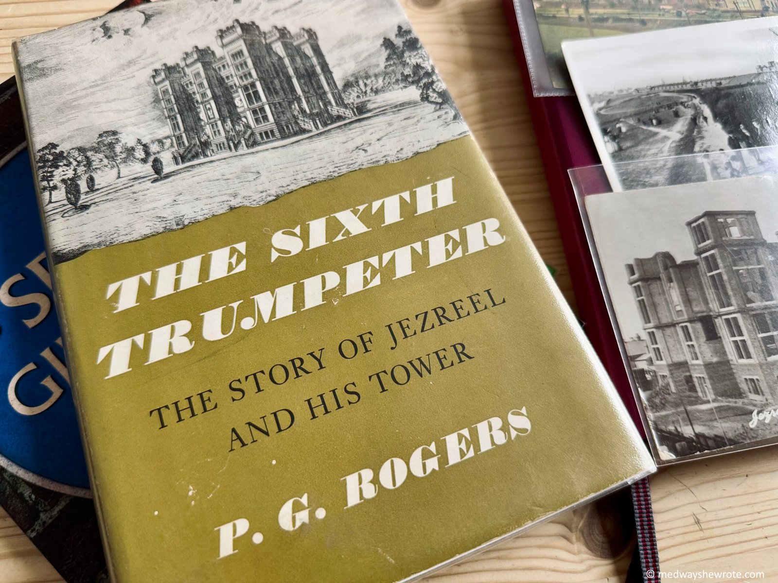 An image of P.G' Rogers' book, The Sixth Trumpeter, with some postcards of Jezreel's Tower beside it.
