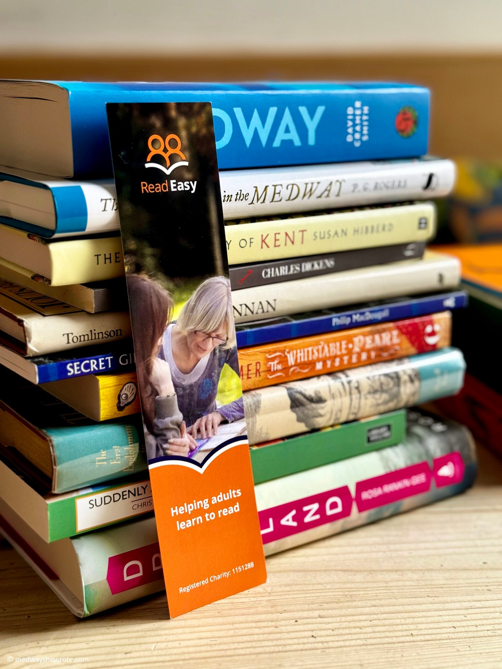 A Read Easy bookmark resting against a pile of Medway and Kent-related books.